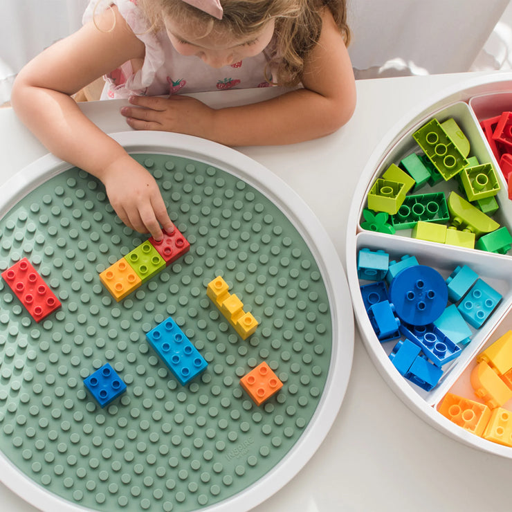 Child placing a building block on to the building block mat