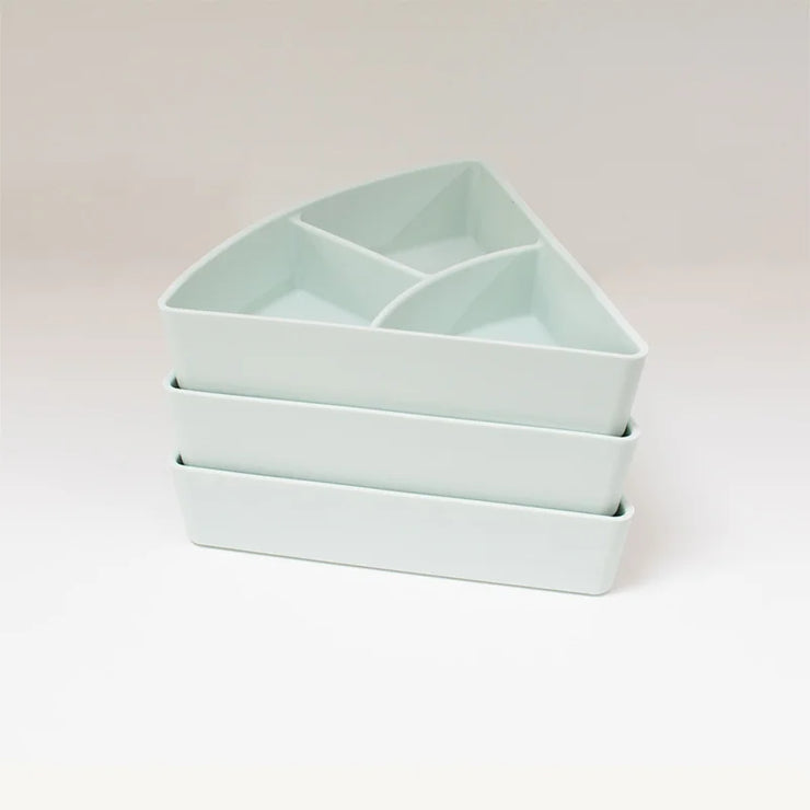 Three triangular shaped storage inserts stacked on top of one another