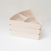 Three triangular shaped storage inserts stacked on top of one another